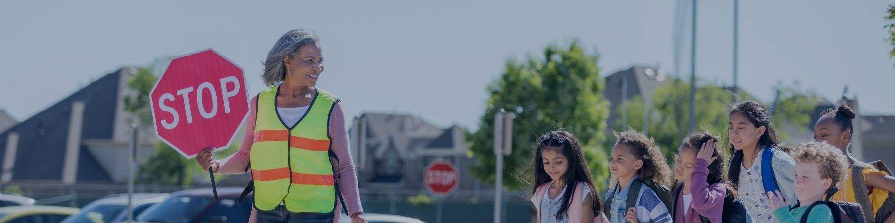 School crossing guard and kids crossing road